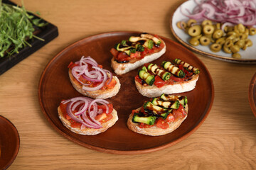 Tasty vegan bruschettas on table in kitchen, closeup