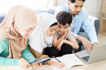 Asian muslim family relaxing in living room together.