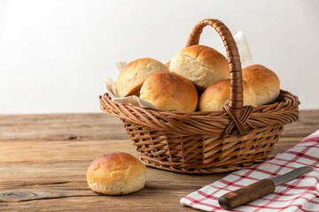 Basket of freshly baked rolls on a wooden table, wooden spoons, baked goods