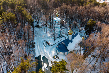 Aerial view of snow-covered cemetery with Orthodox church. Kaluga region, Russia
