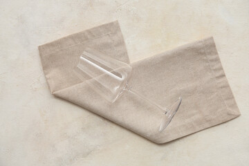 Wine glass with grey napkin on white grunge background