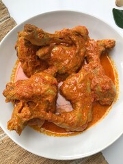spicy red curry chicken on white plate