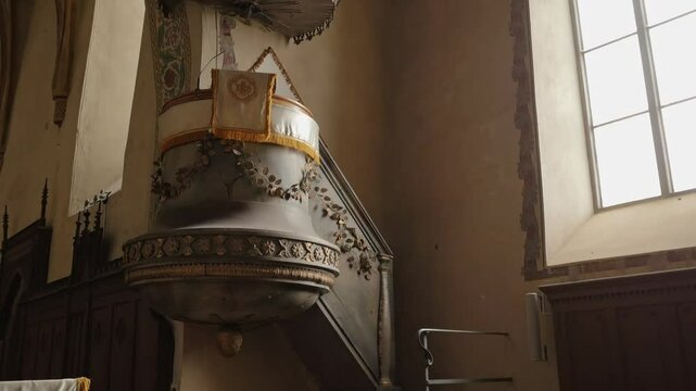 The interior of Codlea's fortified church reveals Gothic vaulted ceilings, stone walls, and wooden pews, capturing its historic beauty and serene ambiance.