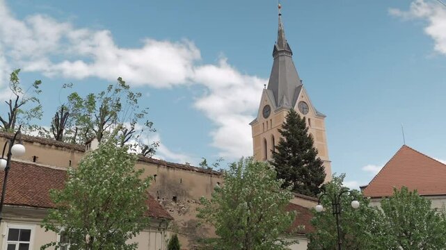 Exterior view of Codlea's fortified church, featuring medieval stone walls, intricate details, and the surrounding landscape, reflecting the region's rich history and architectural heritage.