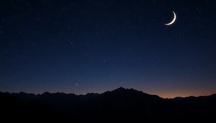 Naklejka premium Crescent Moon over Silhouetted Mountain Range at Night