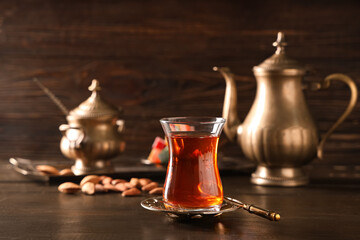 Glass of Turkish tea with spoon on wooden background