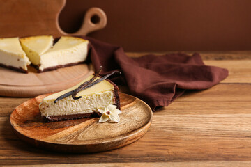 Plate with piece of sweet vanilla cheesecake on wooden table