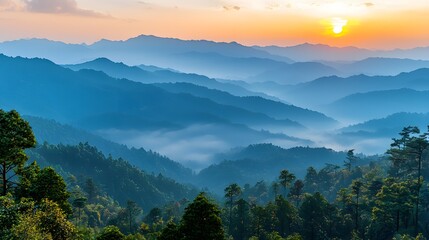 Fototapeta premium Majestic Sunrise Over Misty Mountain Peaks Symbolizing a New Day and Fresh Start Breathtaking landscape with layers of blue hues and a glowing sun breaking through the fog