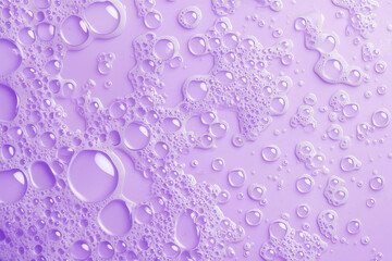 Soap bubble texture on purple background. Abstract close-up view of soap foam bubbles.