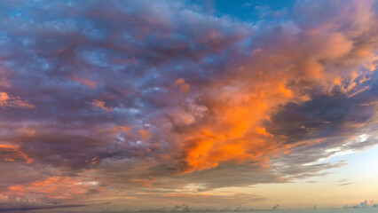 Dramatic sunset sky covered with colorful yellow clouds. Panoramic skyscape