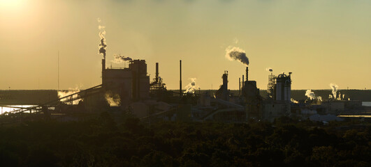 Huge factory with high chimneys polluting atmosphere with carbon dioxide smoke from production...