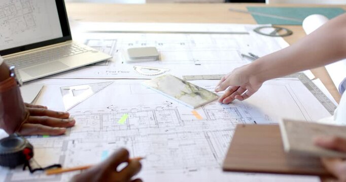 Reviewing blueprints and materials, architects collaborating on construction project