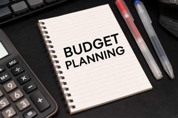 Fototapeta premium BUDGET PLANNING text on Notebook with calculator and office supplies. Budget planning concept