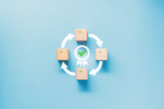 Wood block with document with check mark icon and certificate surround by circle arrow. Quality Assurance Certificate to review and Approval Documents standard guarantee lifecycle.