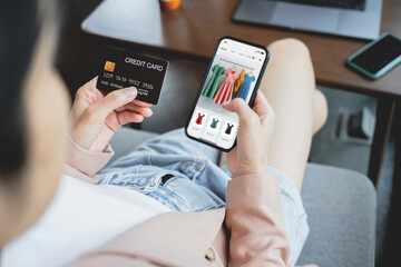 Woman hand holding credit card with smartphone for shopping and paying online using banking app.