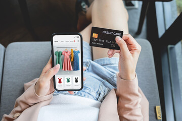 Woman hand holding credit card with smartphone for shopping and paying online using banking app.