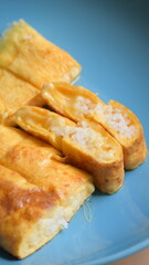 roll omelette stuffed with chesse and rice on blue plate, delicious food in the morning