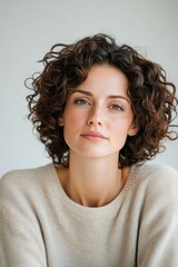 Frustration over limp curls after a perm on a gloomy afternoon in a cozy indoor space