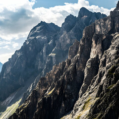 A range of rocky peaks with steep cliffs under a sunny sky ultra HD