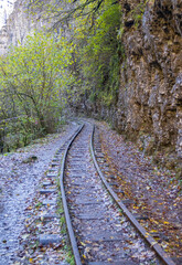 a narrow gauge railway with a solid foundation in a mountainous area in early autumn with panoramic...