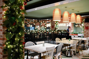 Christmas decoration details on a public vintage restaurant for holiday ambience with hanging lamp and table set