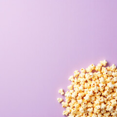 Bright and colorful popcorn on a purple and blue background with ample copyspace, ideal for food blogs, advertisements, and snack promotions.