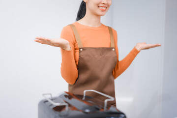 Asian female barista with a beautiful smile, skillfully making coffee in a cozy small shop, creating a warm and welcoming atmosphere for customers in the charming cafe