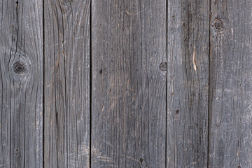 Texture old weathered planks. Surface of darkened from time to time cracked knot boards old fence, wall, table or floor, texture of a natural tree, close-up, high resolution.