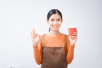 Asian female barista with a beautiful smile, skillfully making coffee in a cozy small shop, creating a warm and welcoming atmosphere for customers in the charming cafe