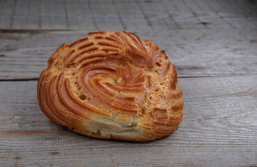 Eclair on a wooden surface. Profiterole cake. Eclair in the form of a ring.