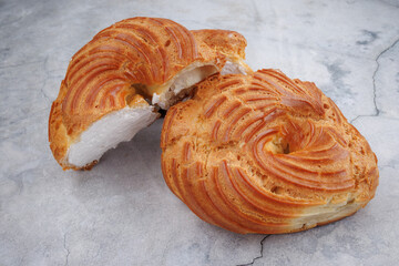 Cut and whole profiterole cake. Eclair with white filling.