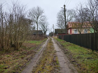A serene and peaceful rural pathway surrounded by nature in overcast weather and clouds