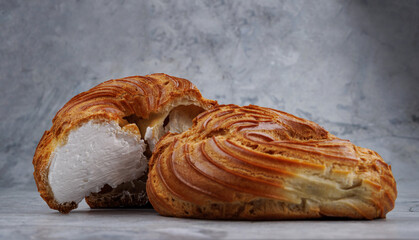 Cut and whole profiterole cake. Eclair with white filling.