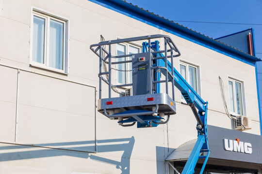 Russia. Samara, August 22, 2024: a new articulated boom lift on a trading platform near a store on a sunny summer day. Text in Russian: gidroremservis