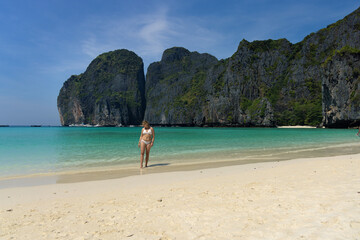 A young woman on a white sand beach in Koh Phi Phi Leh Island, Thailand