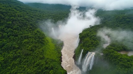 Fototapeta premium Aerial view of lush rainforest waterfalls cascading into river, misty mountains background; travel brochure