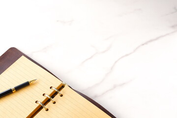 リング式のシステム手帳を開いてデスクワークをしているイメージ
