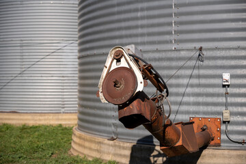 rusted auger unload shoot on a metal grain bins on a family farm.