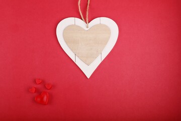 Red heart shapes and an empty wooden heart on red background. Love, heart, Valentine's Day