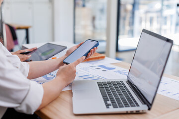 Close up Business woman using calculator and laptop and phone for do math finance on wooden desk, tax, accounting, statistics and analytical research concept