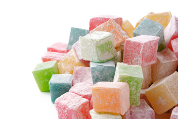 Colorful cubes of traditional confectionery piled together on a white surface, showcasing various distinct flavors and textures