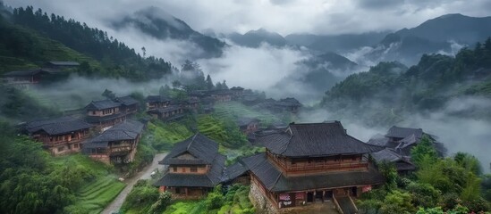 Misty mountain village with traditional houses and terraced fields.