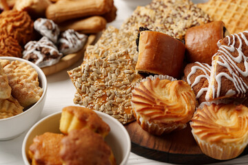 Assortment of baked treats displayed on wooden platter and bowls at a dessert gathering in a cozy setting