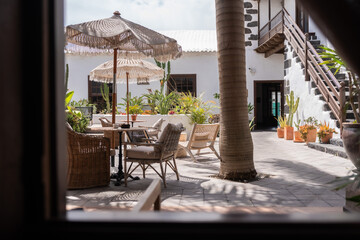 Relaxing courtyard with vibrant plants and cozy seating near a tropical villa