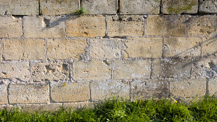 background stone wall brick beige stones texture with green grass floor
