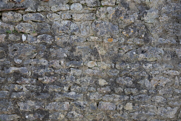 gray background old and weathered rough stone grey cobbled wall