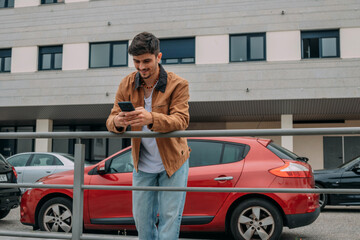 Naklejka premium Casual young man on the street chatting with mobile phone