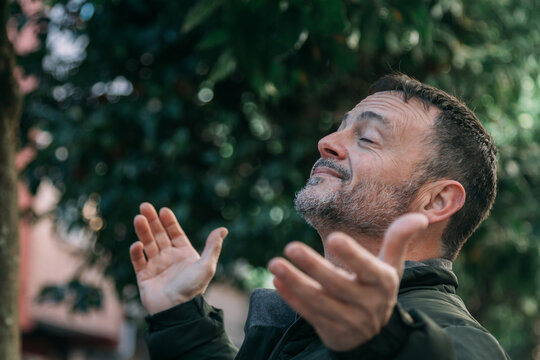 Portrait of man breathing in nature and with open arms