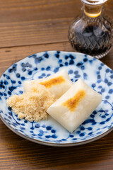 青い和柄の皿に盛られた焼き餅と砂糖醤油