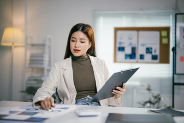 Young professional reviewing documents and data for business insights and strategic planning